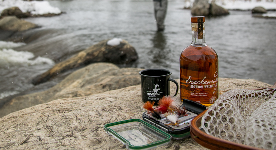 whiskey with fishing lures in front of river